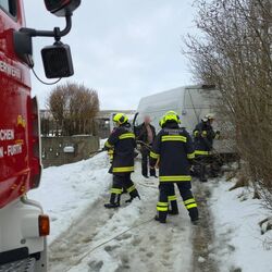 Feuerwehrleute der Freiwilligen Feuerwehr Ausserkasten-Furth bergen einen Van aus dem Schnee auf einer Landstraße.