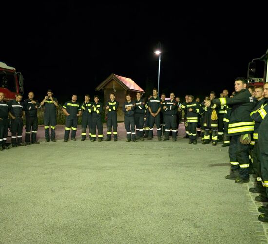 69 Feuerwehrmitglieder stehen bei der Nachbesprechung im Kreis