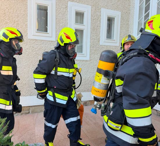 Feuerwehrleute in Schutzkleidung bereiten sich auf einen Einsatz vor, während sie Ausrüstung überprüfen. | © Name