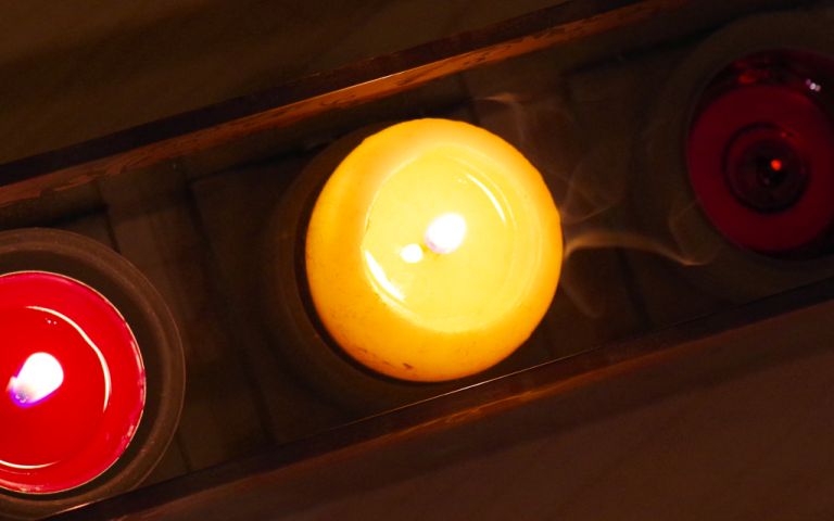 Foto: 3 Kerzen schimmern im Dunkeln