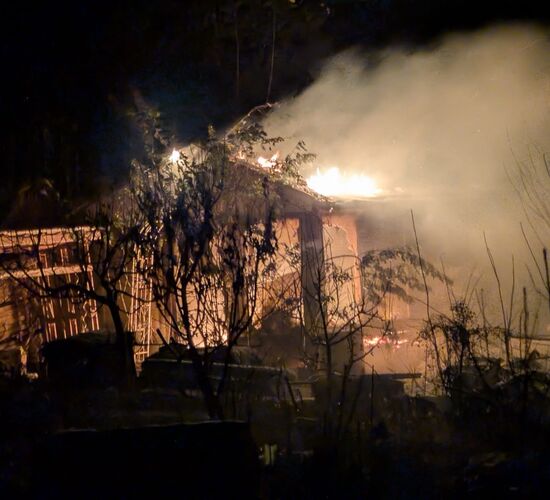 Ein Gebäude steht nachts in Flammen, während dichter Rauch in den dunklen Himmel aufsteigt.