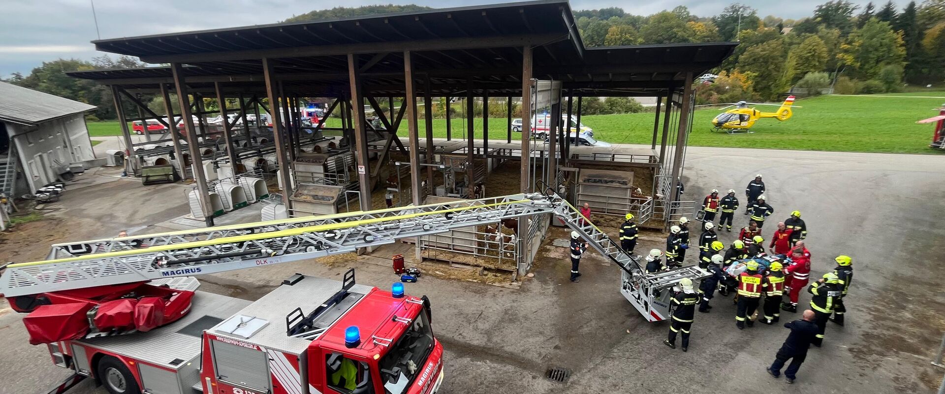 Blick vom Dach, während die Korbtrage von Rettungsdienst und Feuerwehr von der Drehleiter auf eine Rolltrage gelegt wird.