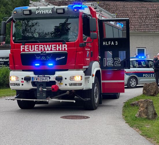 Ein Feuerwehrfahrzeug steht im Vordergrund, dahinter telefoniert ein Polizist neben einem Polizeifahrzeug. | © Michael Schuster
