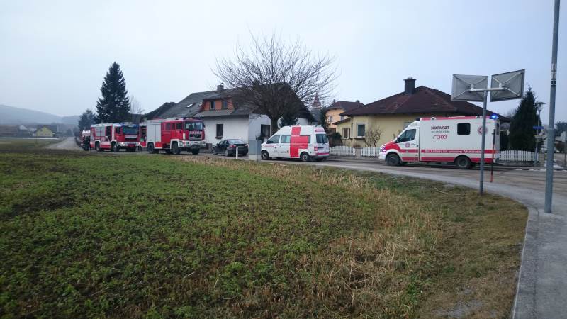 Einsatzfahrzeuge der Feuerwehr und Rettung vor dem Haus