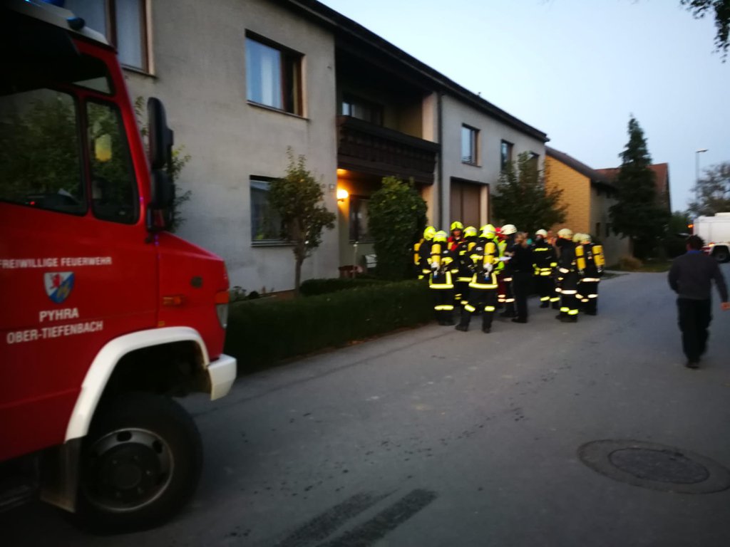 Foto: Zwei mit Atemschutzgeräten ausgerüstete Trupps vor dem Haus