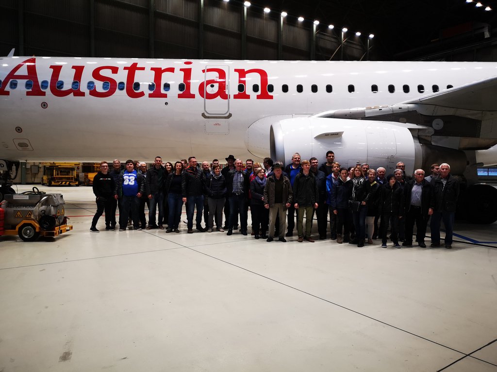 Foto: Alle Teilnehmer der Führung vor einem im Hangar geparkten Flugzeug der Austrian Airlines